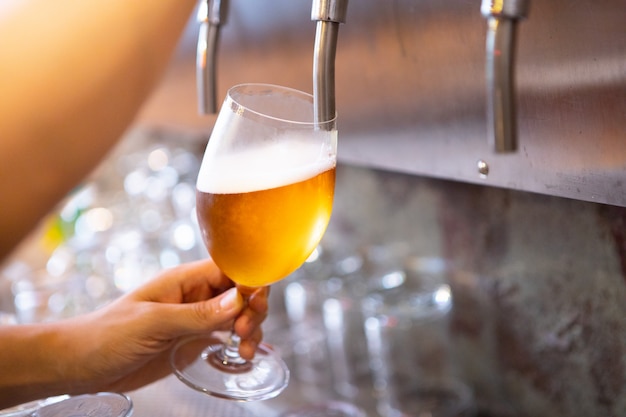 Torneira de cerveja no bar e refresco frio para álcool adulto depois do trabalho