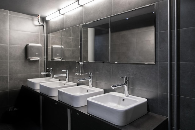 torneiras com lavabo em banheiros públicos em cores cinzentas