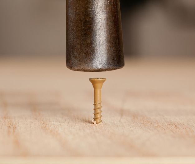 Tornillo golpeado en madera por martillo