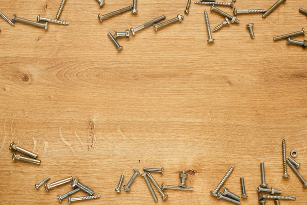 Tornillos en una mesa de madera. Bandera de construcción.