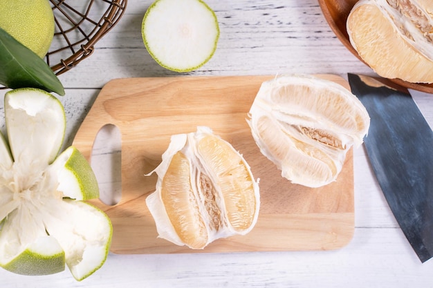 Toronja de pomelo pelado fresco con hojas verdes en una mesa de tablones de madera brillante Fruta de temporada cerca del espacio de copia de la vista superior del festival del medio otoño