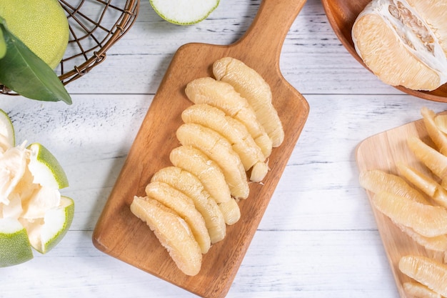 Toronja de pomelo pelado fresco con hojas verdes en una mesa de tablones de madera brillante Fruta de temporada cerca del espacio de copia de la vista superior del festival del medio otoño