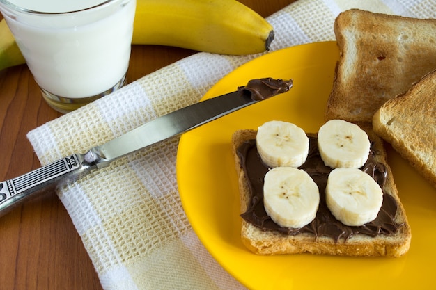 Foto torrada com creme de chocolate, banana e leite no guardanapo amarelo