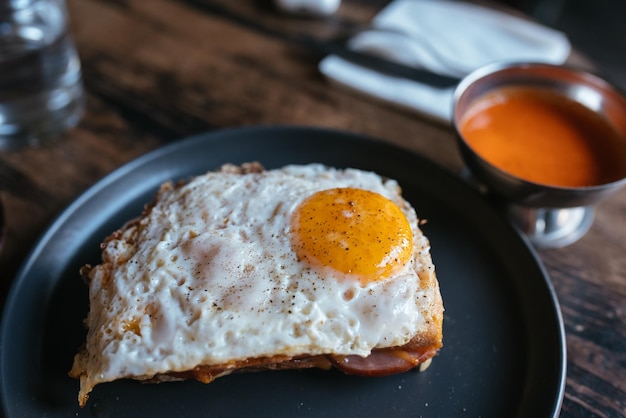 Torrada com queijo e linguiça coberta com ovo frito