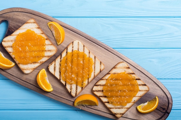 Foto torrada de geleia de laranja caseira em mesa de madeira café da manhã de frutas