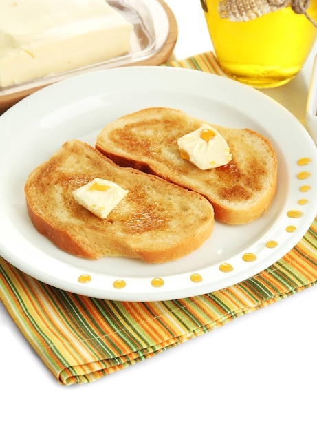 Torrada de pão branco com mel em prato isolado em branco