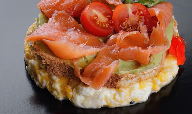 Torrada de pão de café da manhã com ovos mexidos salmão abacate e tomate em um prato preto