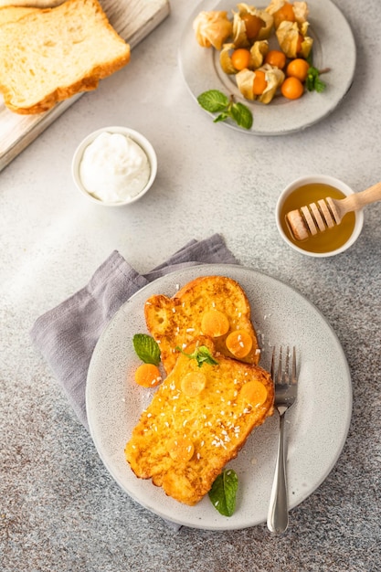 Torrada francesa de brioche com mel physalis e hortelã Café da manhã com pão frito com ovo e leite