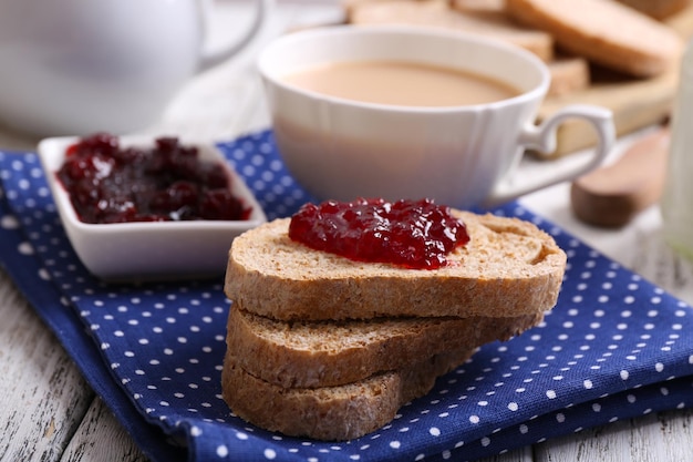 Torrada fresca com geléia e xícara de café na mesa de perto