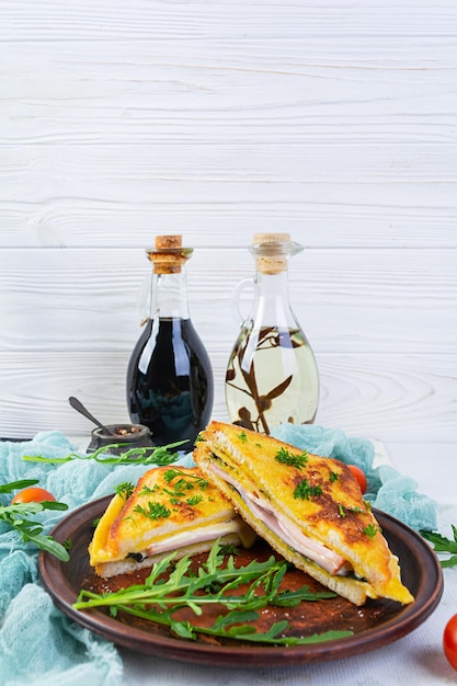 Torradas assadas em ovos mexidos com presunto, ervas e queijo cheddar Delicioso sanduíche de café da manhã grelhado