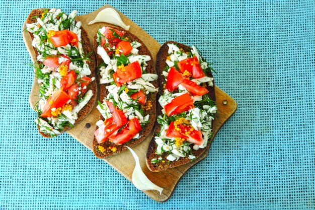 Torradas com queijo branco, tomate e verduras. Torradas vegetarianas úteis. Keto dieta. Keto idéia do almoço. Comida saudável.