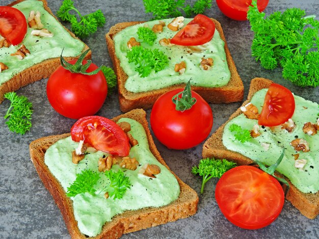 Torradas com queijo cottage verde e nozes e tomate.