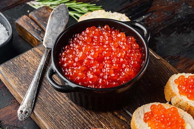 Torradas de canapés com caviar vermelho, no fundo da velha mesa de madeira escura