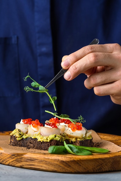 Torradas de pão escuro com fatias de abacate torradas saudáveis com fundo de abacate e Caviar Roe