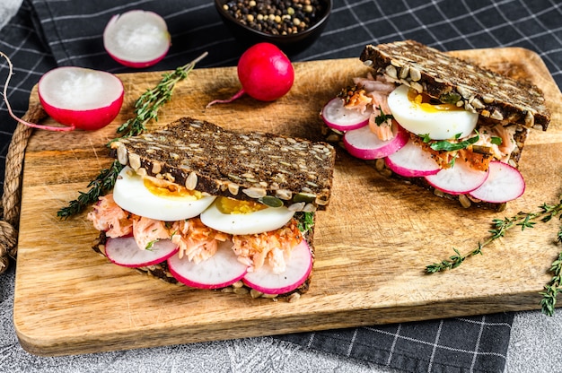 Torradas de pão integral com salmão defumado quente, ovo e rabanete., Vista superior.