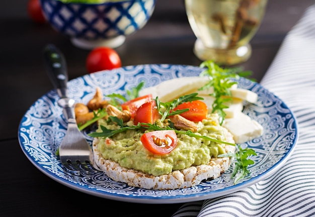 Torradas saudáveis de abacate para o pequeno-almoço ou almoço abacate rúcula tomates caju nozes feta queijo e pimenta sanduíches vegetarianos