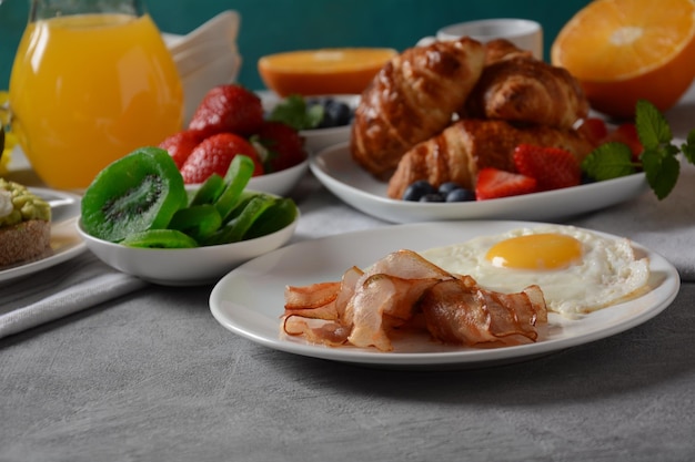 Torradas saudáveis de café da manhã com abacate e bacon de ovo e ovos frescos e suco fresco de frutas secas