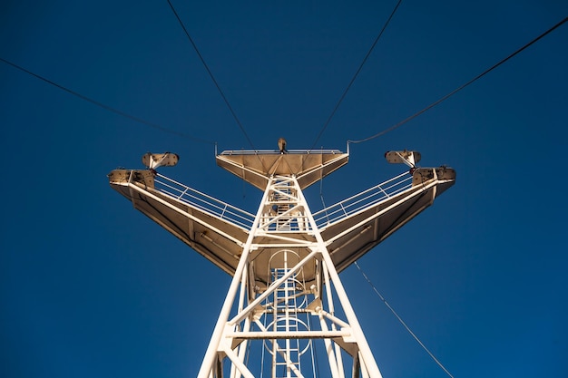 Torre de acero con una línea eléctrica de alto voltaje contra un cielo azul