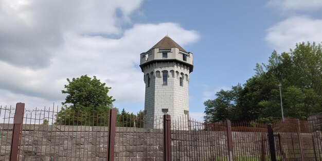 Una torre de agua está rodeada por una valla y una valla.