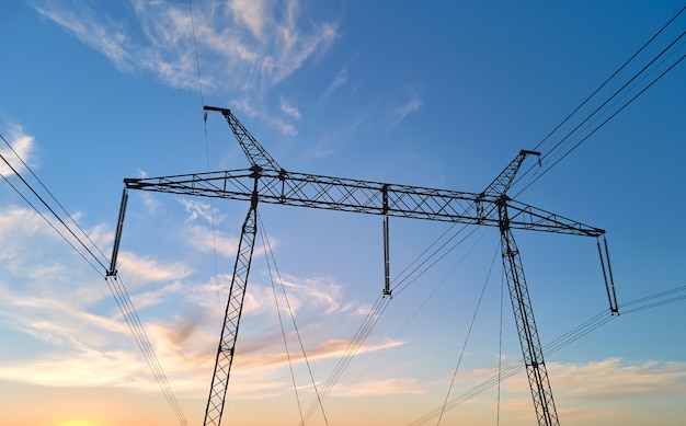 Torre de alta tensión con líneas eléctricas al atardecer Transmisión de electricidad