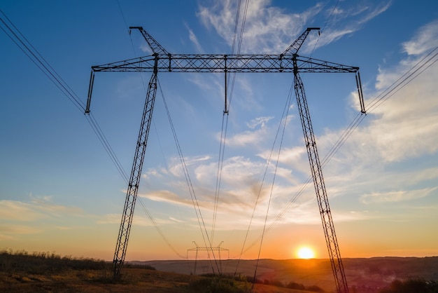 Torre de alta tensión con líneas eléctricas al atardecer Transmisión de electricidad