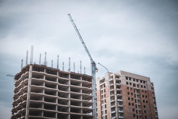 Torre amarela do guindaste de lança de construção contra o céu azul