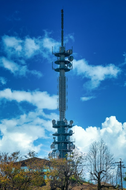 Torre de antena de telecomunicaciones para teléfono móvil con el fondo de cielo azul.