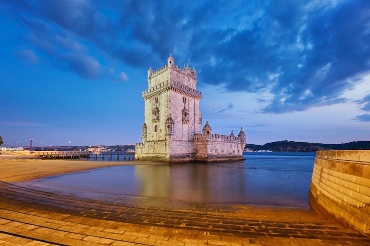Foto torre de belem en la orilla del río tajo en el crepúsculo lisboa portugal