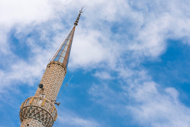 Torre blanca de la mezquita contra el cielo azul