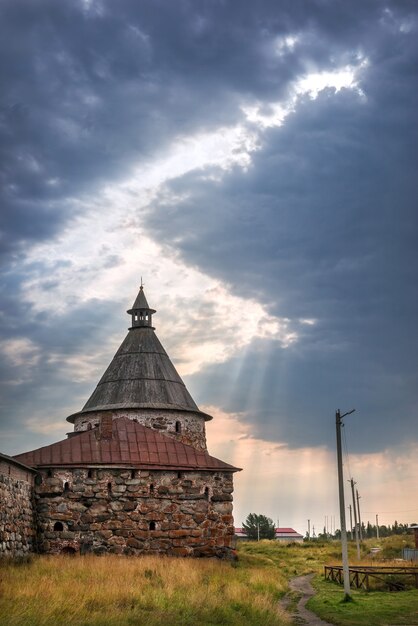 La Torre Blanca del Monasterio Solovetsky bajo nubes azules y un tragaluz con rayos de sol