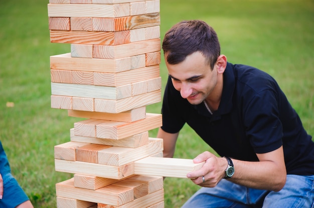 La torre de bloques de madera. Juego grupal de habilidad física con grandes bloques