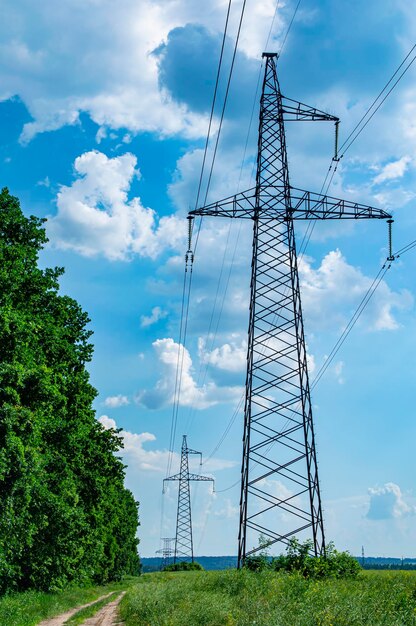 Torre con cables de transmisión de energía de alto voltaje contra el cielo azul