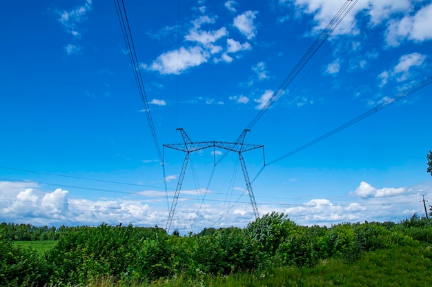 Foto torre com fios de transmissão de energia de alta tensão contra o céu azul