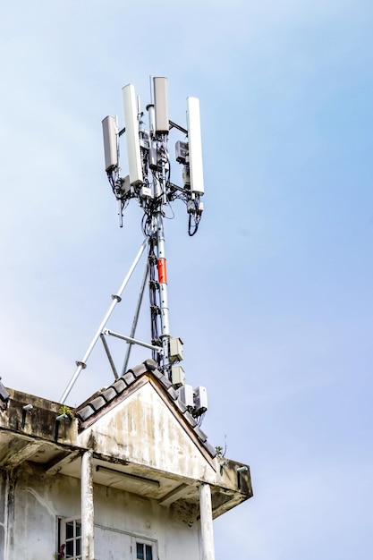 Torre de comunicación con antenas en la parte superior del edificio y fondo de cielo azul brillante