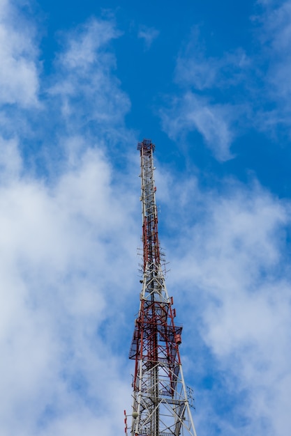 Torre da antena com céu azul e nuvens
