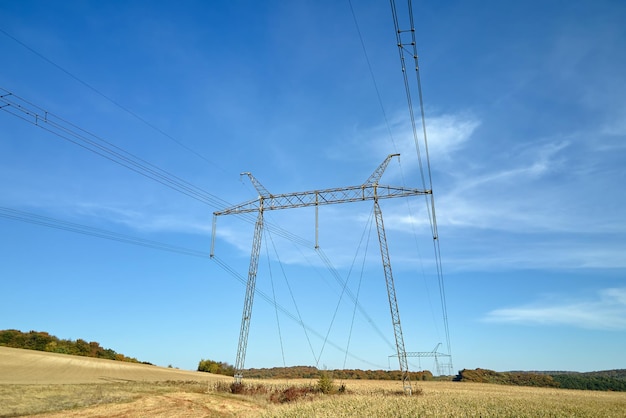 Foto torre de alta tensão com linhas de energia elétrica que transmitem energia elétrica através de fios de cabo