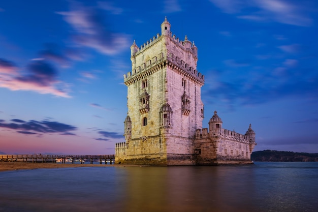 Torre de Belém ou Torre de São Vicente famoso marco turístico de Lisboa e atração turística na margem do Rio Tejo Tejo após o pôr do sol no crepúsculo com céu dramático Lisboa Portugal