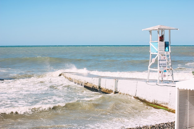 Torre de cabine branca com salva-vidas na costa de invadir o mar negro