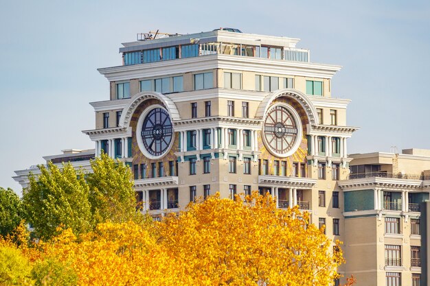 Torre de edifício residencial contemporâneo contra árvores de outono com folhas coloridas