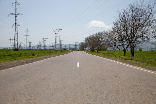 Torre de eletricidade e estrada de asfalto vazia