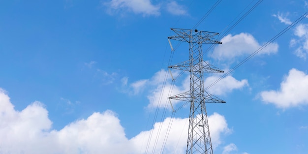 Torre de energia em céu azul com nuvens