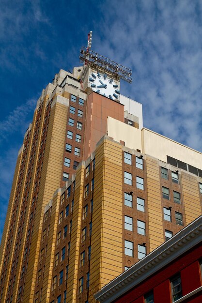 Foto torre de relógio vintage em edifício de vários andares laranja contra o céu azul