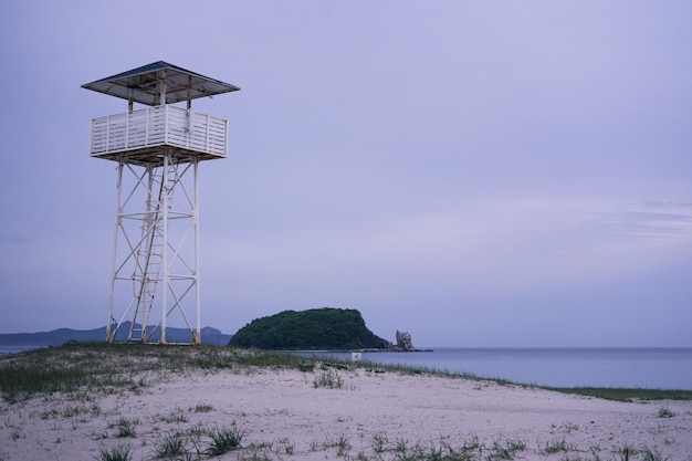 Torre de salva-vidas branca em praia de areia branca