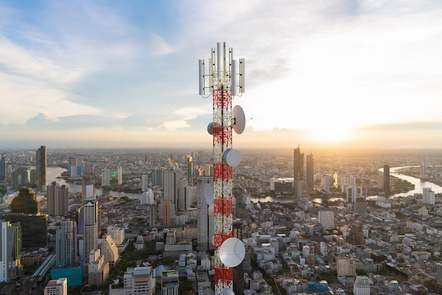 Foto torre de telecomunicações com antena de rede celular 5g no fundo do pôr do sol da cidade