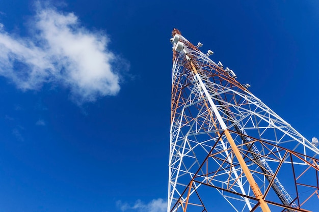 Torre de telecomunicações contra uma torre móvel da torre de rádio do céu azul