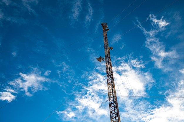 Torre de telecomunicações tendo como pano de fundo um céu incrivelmente lindo com nuvens borradas de branco como a neve