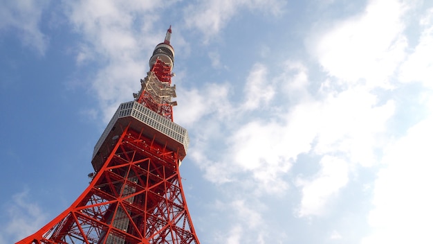 Torre de Tóquio metal aço cor vermelho e branco e céu azul.