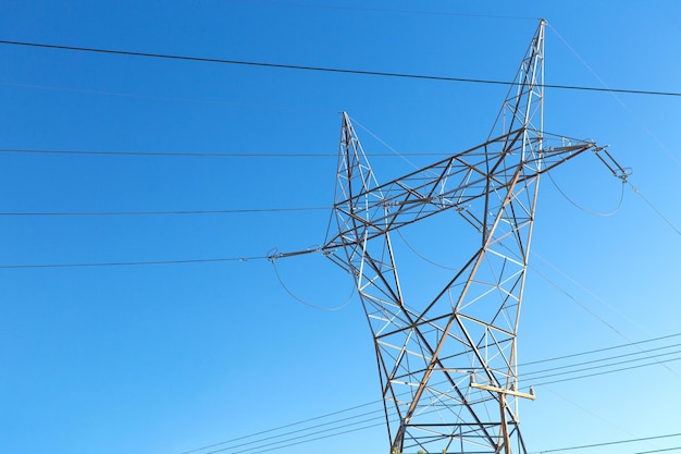 torre de transmissão e linha de energia sobre o céu azul