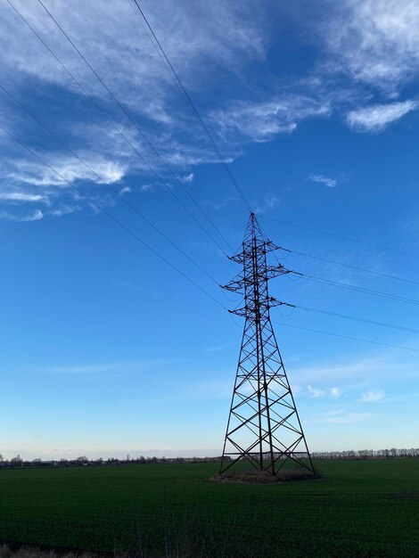 Torre de transmissão no campo verde sob céu azul