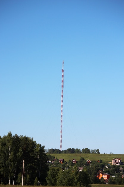 Torre de tv de rádio com fios de cara contra o céu azul profundo claro, close-up. Estrutura de aço com design de treliça vermelha e branca. Copyspace.